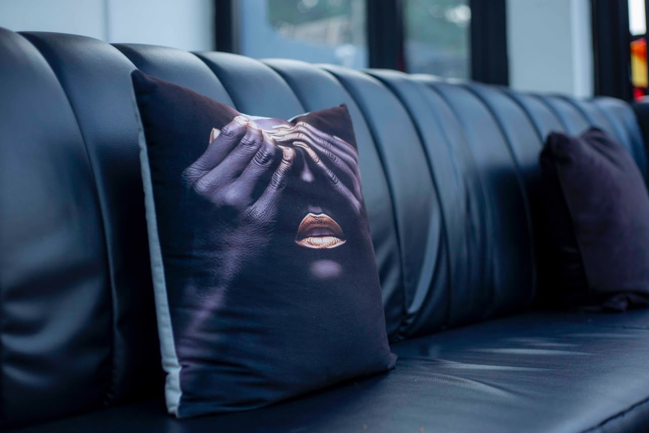Coussin décoratif signature sur banquette de cuir