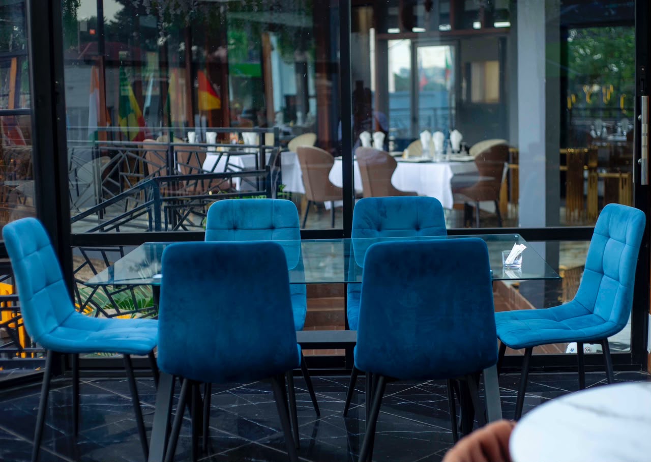 Table en verre entourée de chaises en velours bleu
