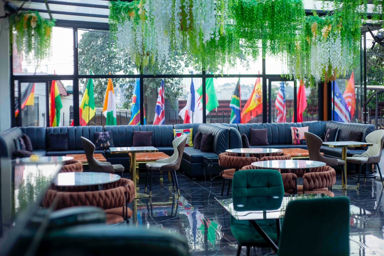 Lounge aux canapés de cuir, drapeaux et verdure suspendue