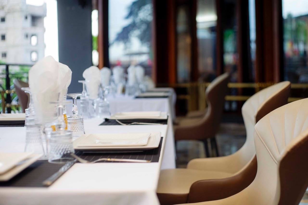 Tables nappées de blanc et fauteuils crème