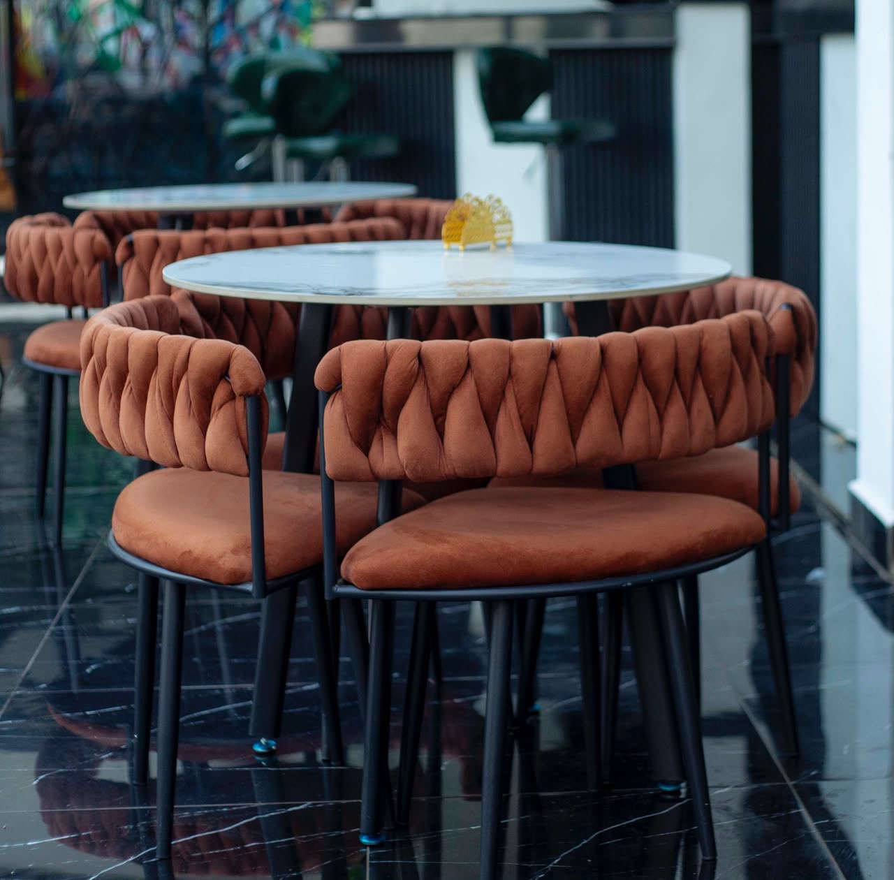Tables rondes en marbre et fauteuils terracotta